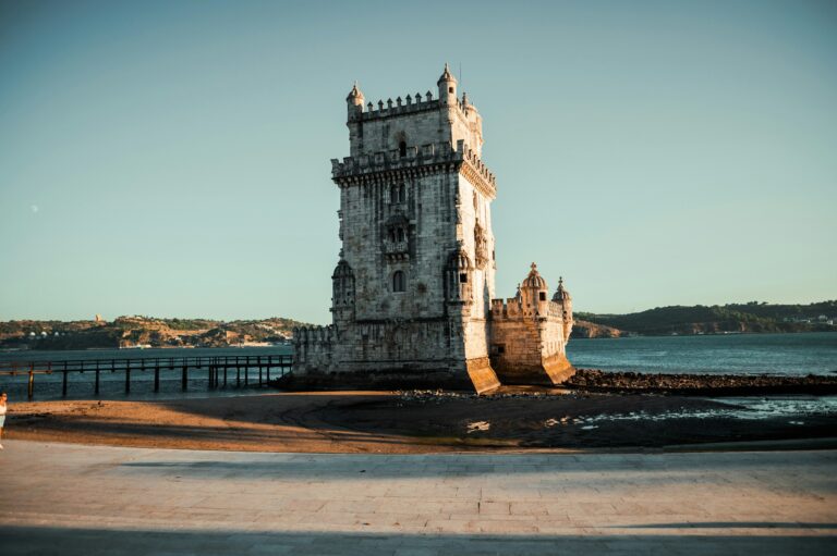 Belem Tower glowing in golden evening light on the Tagus riverfront in Lisbon, symbol of the Portugal golden visa