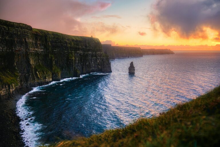 The Cliffs of Moher and Branaunmore sea stack lit by golden sunset light on the Atlantic coast of Ireland, an emblem of Irish residency and citizenship