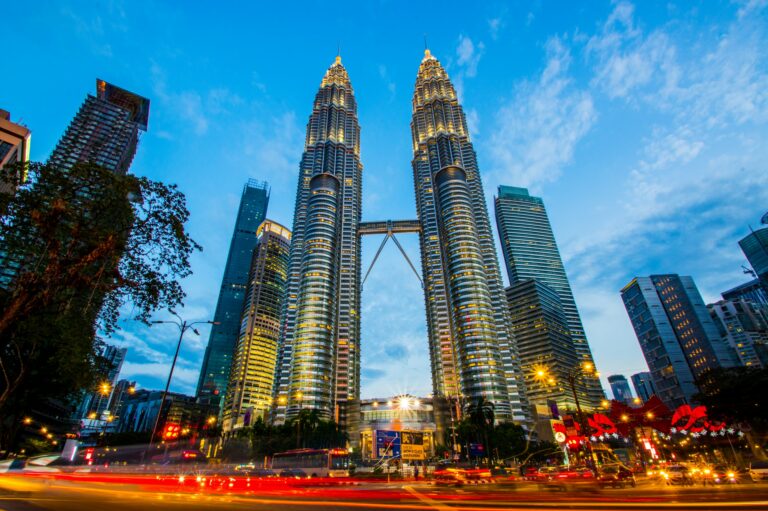 The Petronas Twin Towers illuminated at dusk above the traffic lights of Kuala Lumpur, centrepiece of the Malaysia My Second Home residency
